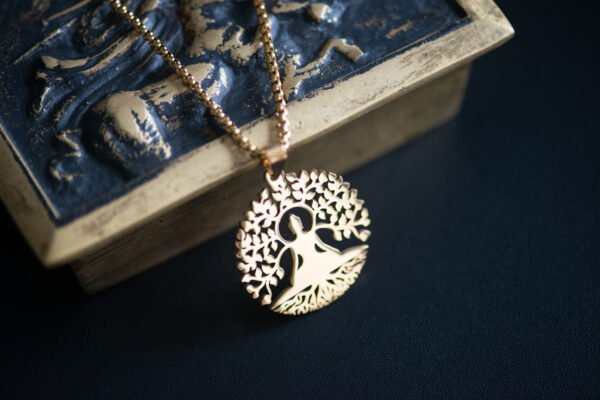 Collier avec pendentif Bouddha et arbre de vie, symbole de sagesse et de connexion spirituelle, parfait pour apporter une touche de sérénité et d'harmonie à votre tenue.