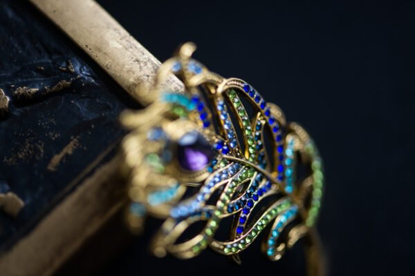 Broche élégante en forme de plume, symbolisant légèreté et liberté, parfaite pour ajouter une touche aérienne à votre tenue.