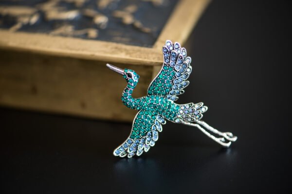 Broche ornée d'un grand héron, capturant l'élégance et la grâce de cet oiseau majestueux, parfait pour rehausser n'importe quelle tenue.