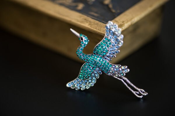 Broche ornée d'un grand héron, capturant l'élégance et la grâce de cet oiseau majestueux, parfait pour rehausser n'importe quelle tenue.