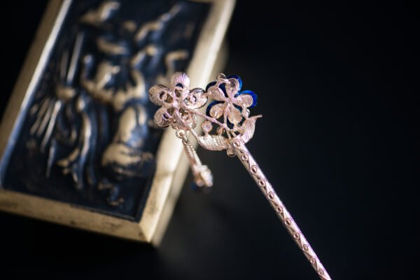 Pic à cheveux orné de fleurs bleues et de strass scintillants, parfait pour apporter une touche de glamour et de couleur à votre coiffure.
