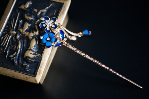 Pic à cheveux orné de fleurs bleues et de strass scintillants, parfait pour apporter une touche de glamour et de couleur à votre coiffure.