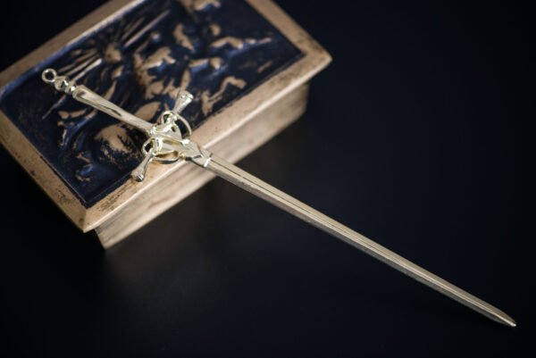 Découvrez notre pic à cheveux épée médiévale d'or, un accessoire léger en métal doré mesurant 20.5 cm de long. Il allie héritage et modernité, avec des motifs raffinés qui symbolisent force et féminité. Parfait pour sublimer vos coiffures lors d'événements ou au quotidien, il est expédié soigneusement avec suivi. Cet accessoire devient le symbole de votre légende, unissant passé et présent.